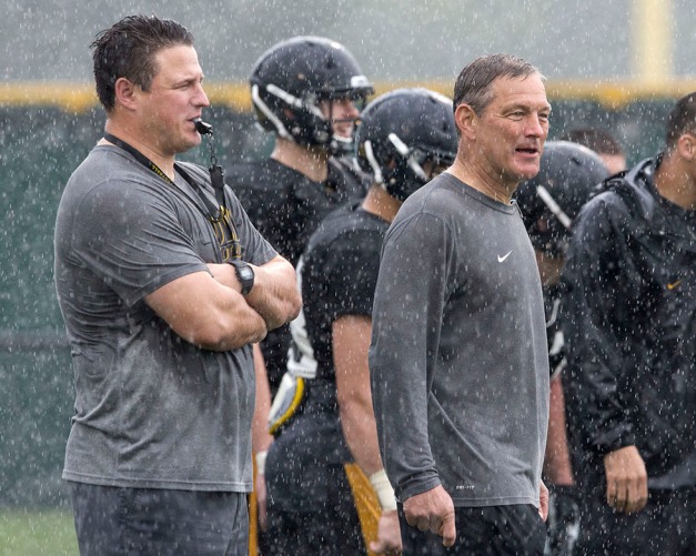 Iowa Hawkeyes offensive line coach Brian Ferentz stands with head coach Kirk Ferentz in the rain during their 14th  Outback Bowl practice Sunday, Dec. 29, 2013 in Tampa.  (Brian Ray/hawkeyesports.com)
